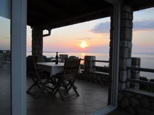 a table and chairs on a balcony with a sunset at House Nevenka in Štivan +14 photos