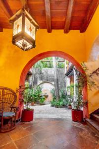 a yellow wall with an archway in a room with plants at Casa Baloco in Cartagena de Indias