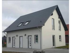 un edificio blanco con techo negro en Moderne Ferienwohnung mit Sauna & Terrasse, en Burhave