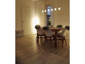 comedor con mesa y 4 sillas en Moderne Ferienwohnung mit Sauna & Terrasse, en Burhave