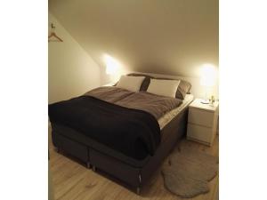 Un dormitorio con una cama grande con dos almohadas. en Moderne Ferienwohnung mit Sauna & Terrasse, en Burhave