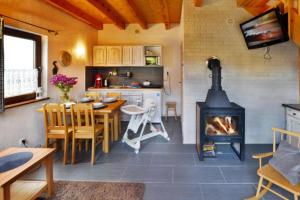a kitchen and dining room with a fireplace and a table at Comfortable holiday homes close to the beach in Bobolin
