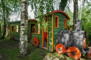a green play house sitting next to a tree at Comfortable holiday homes close to the beach in Bobolin