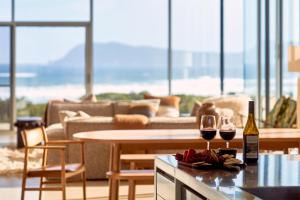a living room with two glasses of wine on a table at Cloudy Bay Beach House - Luxury Escape in Bruny Island in South Bruny