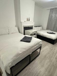 ein Schlafzimmer mit zwei Betten und einem Kamin in der Unterkunft Comfort rooms near City Airport in London