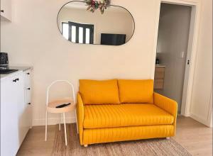 an orange couch in a living room with a mirror at Surfside Retreat-Stylish Escape in Bulli