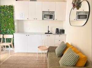 a living room with a couch and a kitchen at Surfside Retreat-Stylish Escape in Bulli