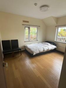een slaapkamer met een bed en 2 stoelen. bij 青山ハウス in Otaru