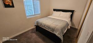 a small bedroom with a bed with white sheets and a window at Lovely Rural Living in Cherry Valley