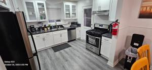 a kitchen with white cabinets and stainless steel appliances at Lovely Rural Living in Cherry Valley