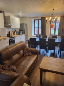 un salon avec un canapé et une table et une cuisine dans l'établissement La ferme de la Semois au bord de l'eau, à Laviot