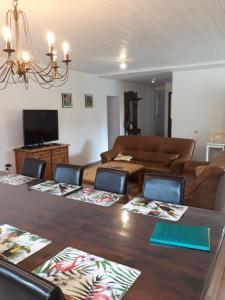 un salon avec une grande table et un canapé dans l'établissement La ferme de la Semois au bord de l'eau, à Laviot 75 autres photos