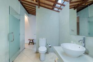 a bathroom with a white toilet and a sink at Villa Tegal Tis Ubud in Payangan +20 photos