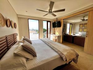 a bedroom with a large bed with a ceiling fan at Luxury Boutique Apartments by Xarm Apartments in Santa Marta +34 photos