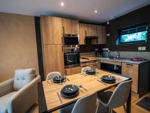 a kitchen and dining room with a wooden table and chairs at Mountain-view eco-friendly cottage in Marcoux