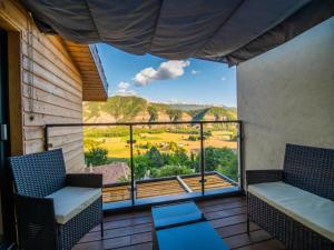 a balcony with two chairs and a view of the mountains at Mountain-view eco-friendly cottage in Marcoux