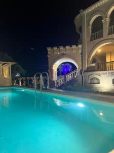 a swimming pool at night with a party in the background at Otyak Plaza in Pʼarakʼar