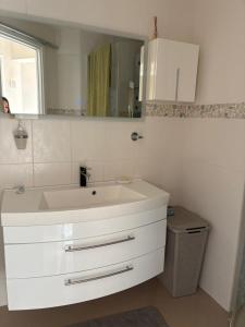 une salle de bains avec un lavabo blanc et un miroir dans l'établissement Villa Ocre, à La Celle-sous-Gouzon