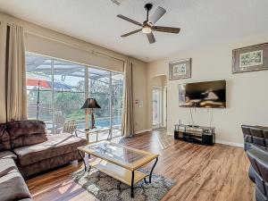 un salon avec un canapé et un ventilateur de plafond dans l'établissement Spacious Villa W Pool, Spa & Game Room, à Orlando