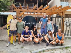 a group of people posing for a picture in front of a sign at Nômades Beach House - Adventure Hostels in Florianópolis