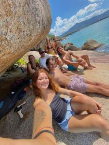 a group of people sitting on the beach at Nômades Beach House - Adventure Hostels in Florianópolis +44 photos