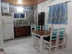 a kitchen with a table and chairs and a refrigerator at El monito de Sanber in San Bernardo