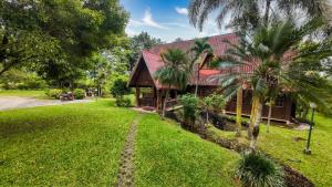 a house with a red roof and a green yard at Babazia Community in Pai