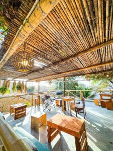 eine Terrasse mit Tischen und Stühlen und einer Holzdecke in der Unterkunft Villa Naylamp Loft 2 familiar playa pocitas in Máncora