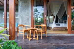 a room with a table and two chairs and a bed at Asiki Villa Sebatu in Tegalalang