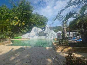 a pool with a water slide in a resort at Diuwak in Dominical