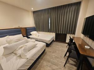 a bedroom with two beds and a desk and a television at meetstar in Hsia-pu-hsia