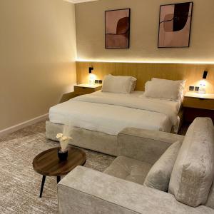 a hotel room with a large bed and a couch at نسيم الحرم 3 in Ash Shishah