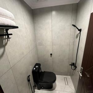 a bathroom with a black toilet in a room at نسيم الحرم 3 in Ash Shishah
