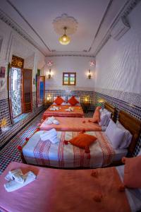 una habitación de hotel con 3 camas. en Riad Layali noor, en Fez