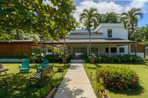 a house with two chairs and a garden at New! Gorgeous Portillo Beach Villa W Pool & Staff in Abra Grande