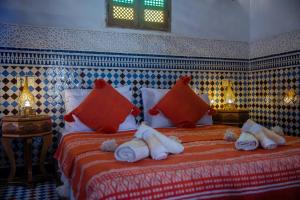 Un dormitorio con una cama grande con almohadas rojas. en Riad Layali noor, en Fez