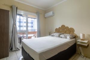 um quarto com uma cama grande e uma janela em Apto 604 vibes em Capão da Canoa