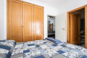 una camera con un letto con una trapunta blu e bianca di Cabanas Coastal Escape a Tavira Altre 5 foto