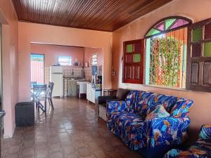 a living room with a couch and a kitchen at Refúgio familiar in Belém