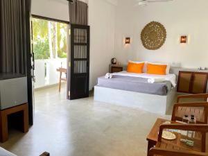 a bedroom with a bed with orange pillows at Lum Residence in Ahangama +62 photos