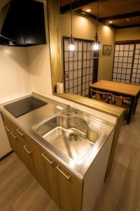 a kitchen with a stainless steel sink and a table at 滋庵 jian okayama in Okayama