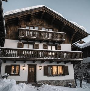 ein Holzhaus mit Balkon im Schnee in der Unterkunft Imperial Heights in Cortina d'Ampezzo