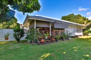 a house with potted plants in the yard at Tropical cocoon with 2 bedrooms in Papeete