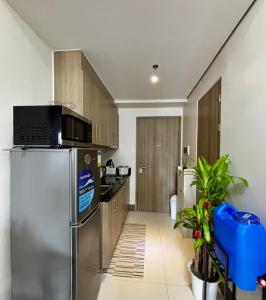 SampongFame Residences 26th Floor Tower 4的厨房配有不锈钢冰箱和木制橱柜