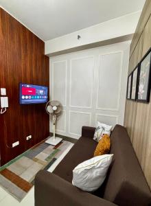 a living room with a couch and a flat screen tv at Fame Residence Tower 4 near Greenfield and Shaw MRT in Manila