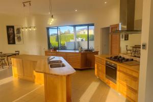 eine Küche mit Holzschränken und einem großen Fenster in der Unterkunft Spacious Family Home - Collingwood Golden Bay in Collingwood