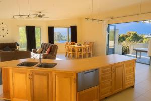 eine Küche und ein Wohnzimmer mit Tisch und Stühlen in der Unterkunft Spacious Family Home - Collingwood Golden Bay in Collingwood