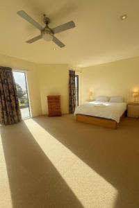 ein Schlafzimmer mit einem Bett und einem Deckenventilator in der Unterkunft Spacious Family Home - Collingwood Golden Bay in Collingwood