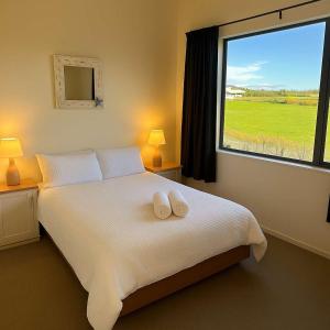 ein Schlafzimmer mit einem Bett mit zwei weißen Handtüchern darauf in der Unterkunft Spacious Family Home - Collingwood Golden Bay in Collingwood