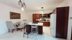 Una cocina con una mesa y un refrigerador blanco. en Villa luxury Cabarete, en Cabarete